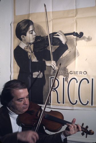 Ruggiero Ricci with a poster of him as a child prodigy - The Finest Photos